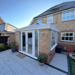 A conservatory in Stapleford, Nottingham with a glass roof, french doors and a vertical radiator