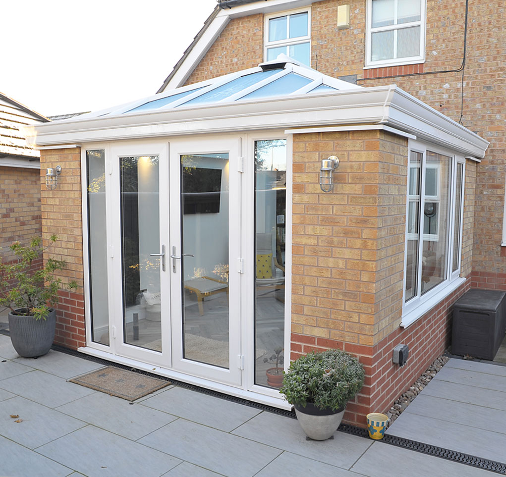 A conservatory in Stapleford, Nottingham with a glass roof, french doors and a vertical radiator